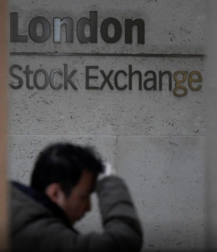 People walk past the London Stock Exchange Group offices in the City of London, Britain - Avaz