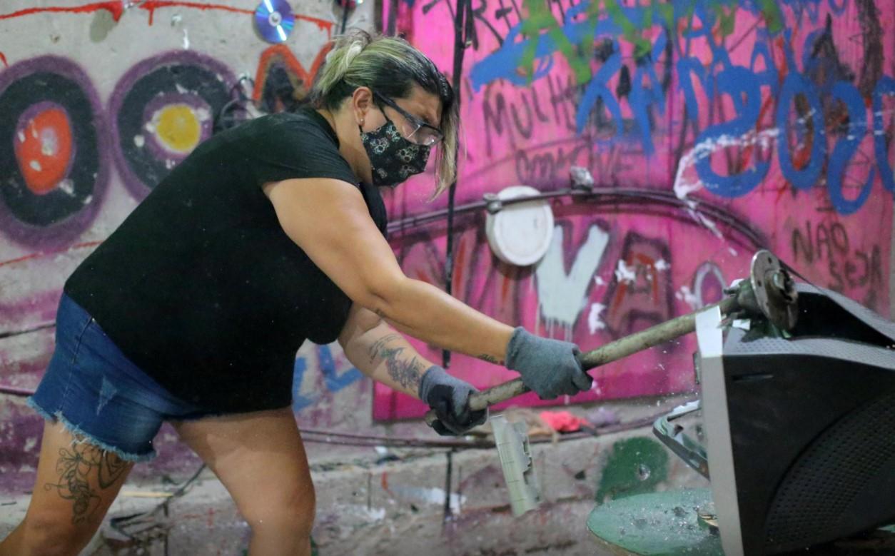 Luciana Holanda smashes a computer monitor at the Rage Room, a place where people can destroy everyday objects to vent their anger, in Sao Paulo, Brazil, February 19, 2021. - Avaz