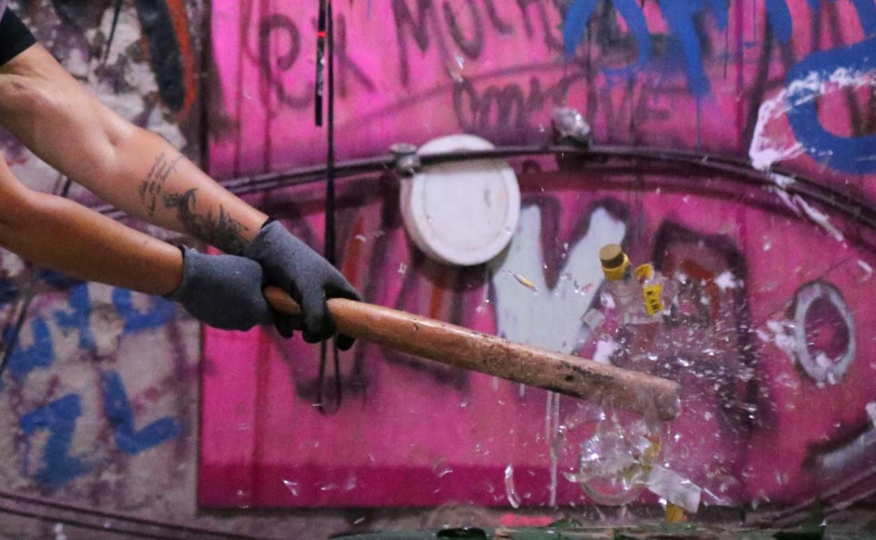 Luciana Holanda smashes a bottle at the Rage Room, a place where people can destroy objects to vent their anger, in Sao Paulo, Brazil, February 19, 2021. - Avaz