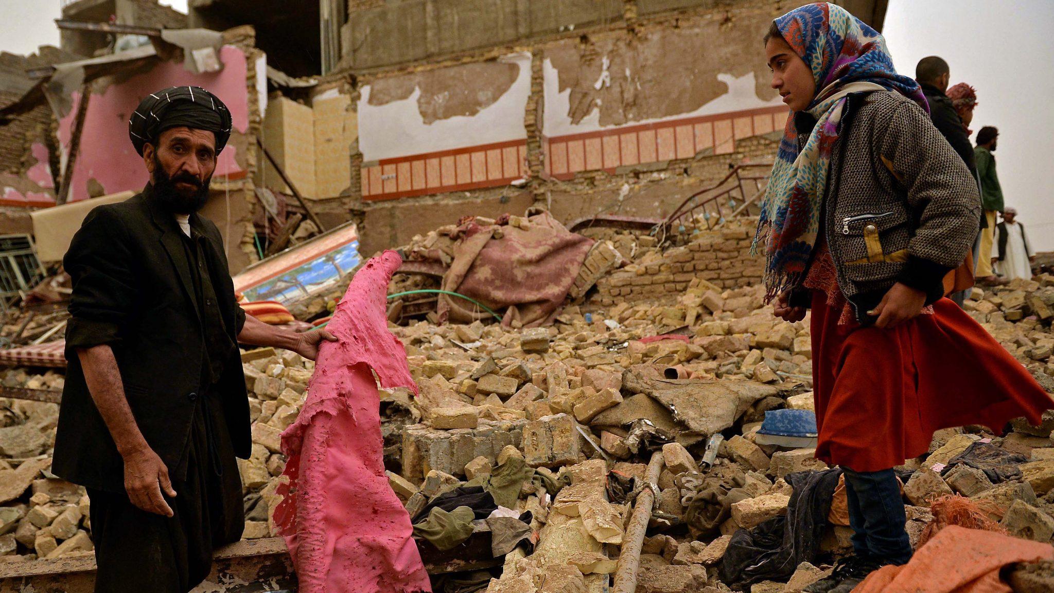 Residents stand amid the debris of a damaged house after a car bomb blast in Herat on March 13, 2021. - Avaz