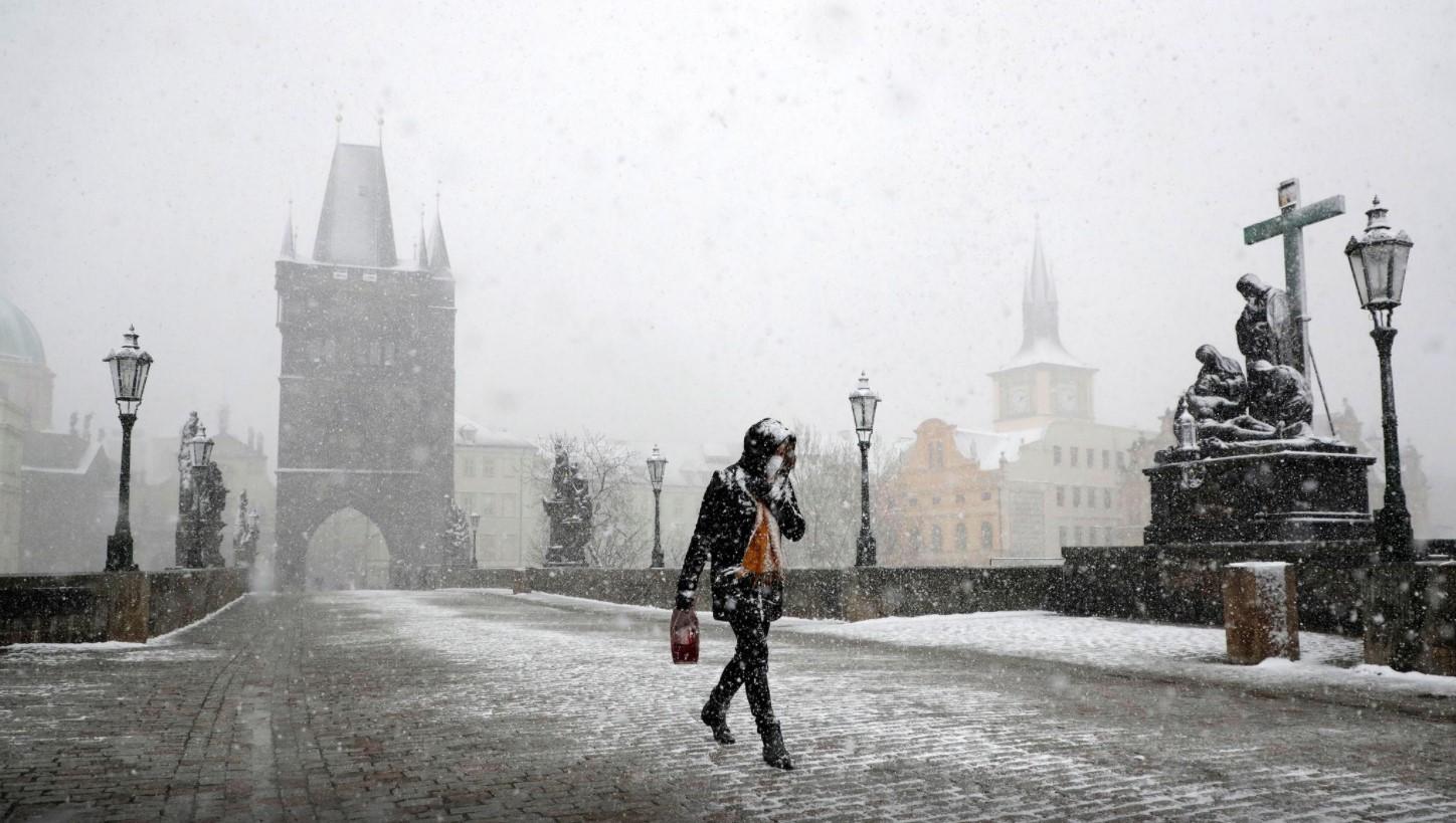 A woman walks across the medieval Charles Bridge during snowfall amid the coronavirus disease (COVID-19) outbreak in Prague, Czech Republic, April 6, 2021. - Avaz