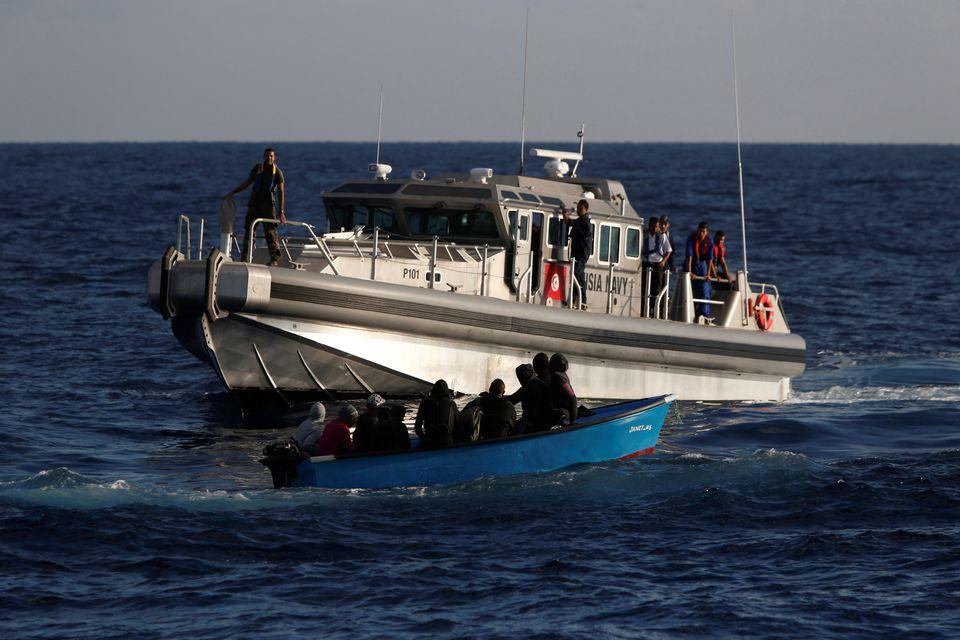 Migrants on a wooden boat are rescued by a patrol vessel of the Tunisia Navy, seen from the migrant search and rescue vessel MV Seefuchs of the German NGO Sea-Eye in the search and rescue zone south of the Al Jurf Oilfield in international waters off the coast of Libya, September 30, 2017. - Avaz