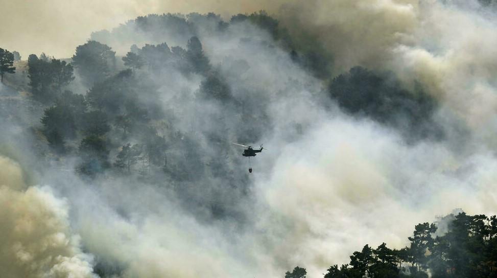 A Lebanese army helicopter drops water on a huge forest fire in the remote Akkar region of the north - Avaz