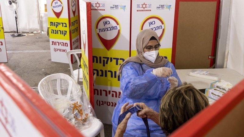 A health worker prepares a swab sample for Covid-19 rapid antigen tests at the Magen David Adom drive-thru testing facility in Tel Aviv - Avaz