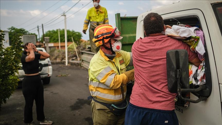 Officials help during an evacuation process as Mount Cumbre Vieja continues to erupt in El Paso, spewing out columns of smoke, ash and lava on the Canary island of La Palma on September 21, 2021. - Avaz