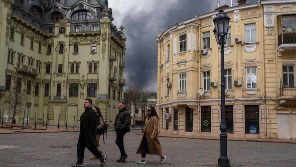 People walk in a street as smoke rises in the air after shelling in Odesa, Ukraine, Sunday, April 3, 2022. The United Nations' cultural agency decided on Wednesday Jan.25, 2023 to add the historic center of Ukraine's Black Sea port city of Odesa to the list of World Heritage in danger - Avaz